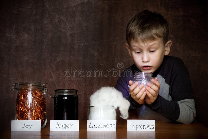 European appearance boy. In jars next to him joy, anger, laziness. In the hands of a child a jar of happiness