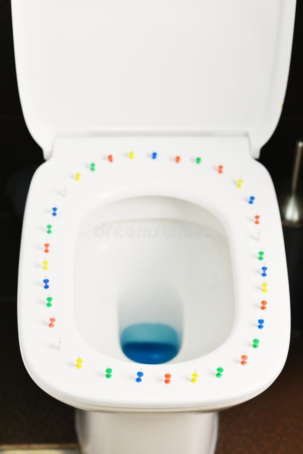 Conceptueel beeld van een hemorrhoidziekte met multi-colored punaisen op de dekking van de toiletkom royalty-vrije stock afbeeldingen Conceptueel beeld van een hemorrhoidziekte met multi-colored punaisen op de dekking van de toiletkom royalty-vrije stock afbeeldingen