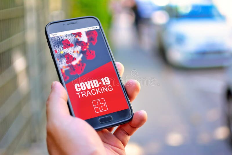 Concepção do Corona Virus Tracking App com telefone celular à mão com design de aplicação na tela em frente à rua indefinida