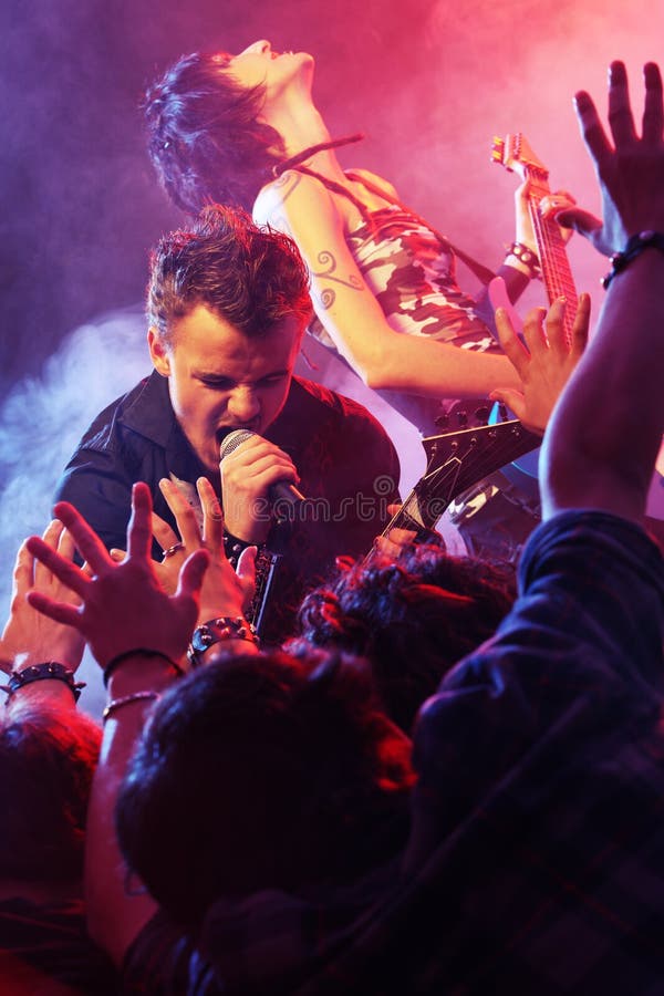 Performing on stage. Влюбленные на рок концерте.