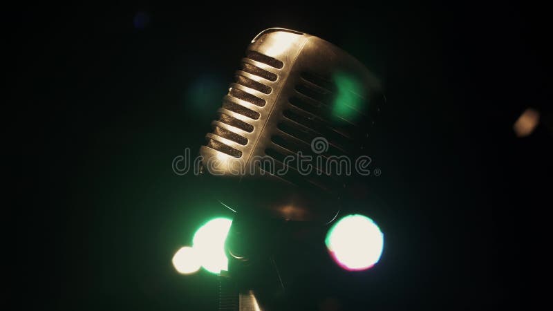 Concert metal glitter microphone stand on stage in retro club. Green spotlights.