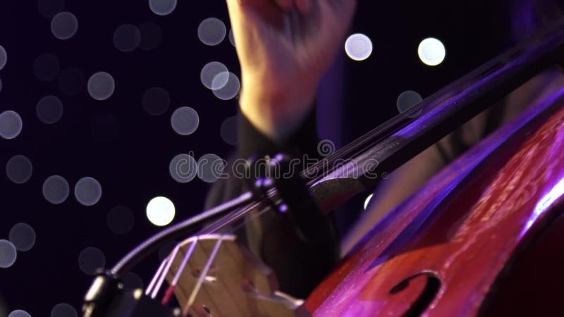 Concert, a musician pinching the strings cello, fingers close up. stock video