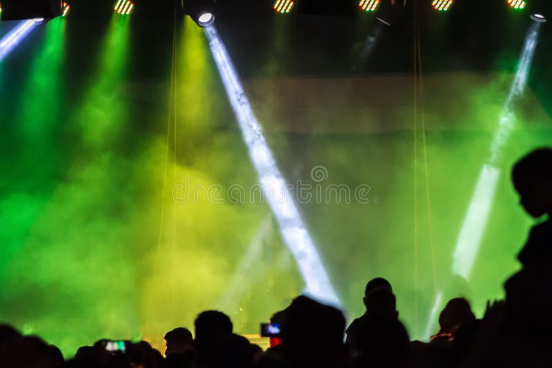 Concertez la foule assistant à un concert, les gens que les silhouettes sont évidentes, éclairé à contre-jour par les feux verts photographie stock Concertez la foule assistant à un concert, les gens que les silhouettes sont évidentes, éclairé à contre-jour par les feux verts photographie stock