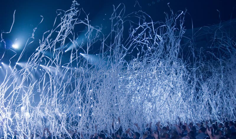 Streamers being thrown out at the end of a rock concert. People raising arms to catch them. Streamers being thrown out at the end of a rock concert. People raising arms to catch them.