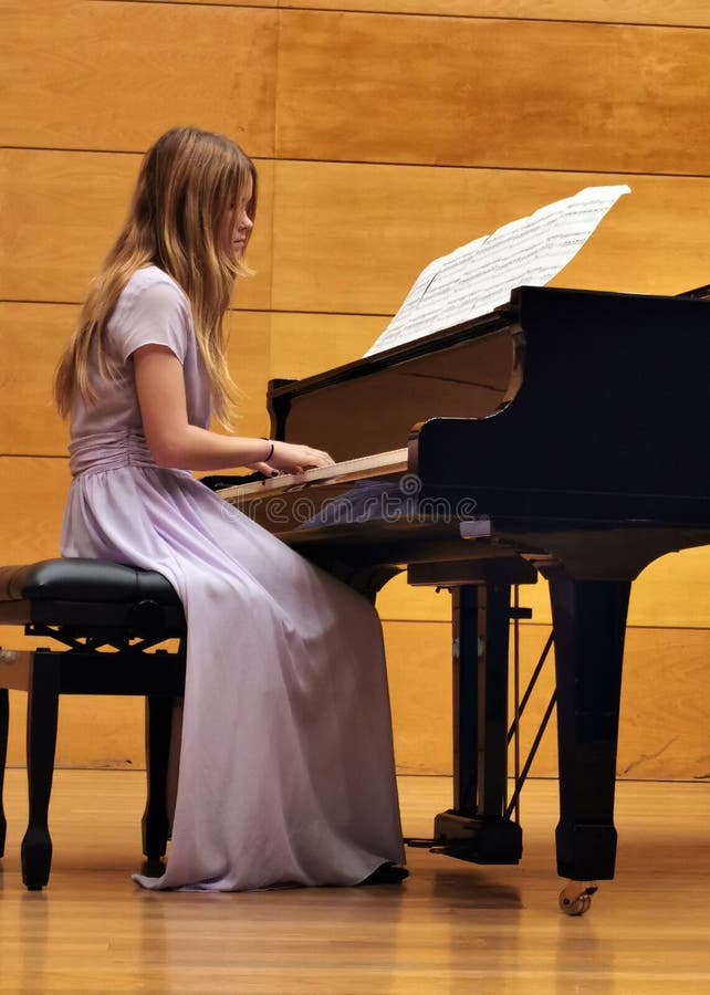 Menina aprende a tocar piano com música online para ensino à