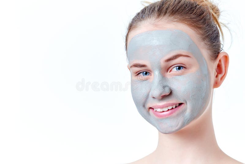 Concetto adolescente dello skincare Giovane ragazza sorridente della testarossa con il ritratto facciale secco della maschera del fotografia stock Concetto adolescente dello skincare Giovane ragazza sorridente della testarossa con il ritratto facciale secco della maschera del fotografia stock