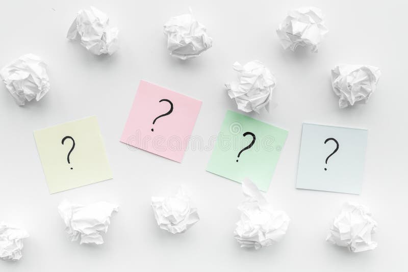 FAQ concept. Question mark on sticky notes near crumpled paper on white background top view. FAQ concept. Question mark on sticky notes near crumpled paper on white background top view.