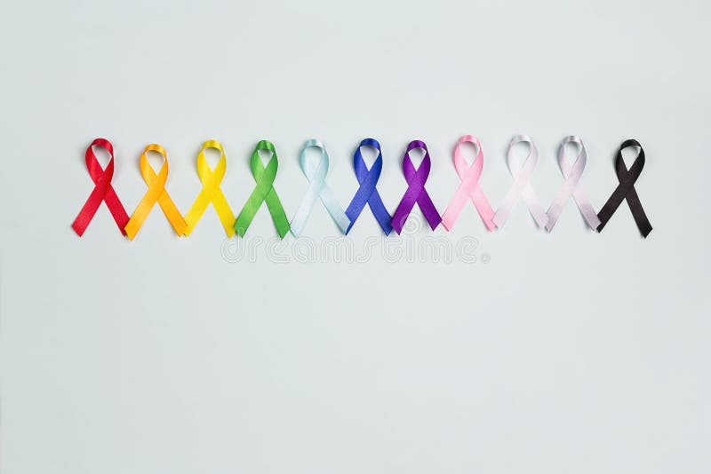 Concetto della Giornata mondiale del cancro, 4 febbraio Nastri di consapevolezza colorati su sfondo blu