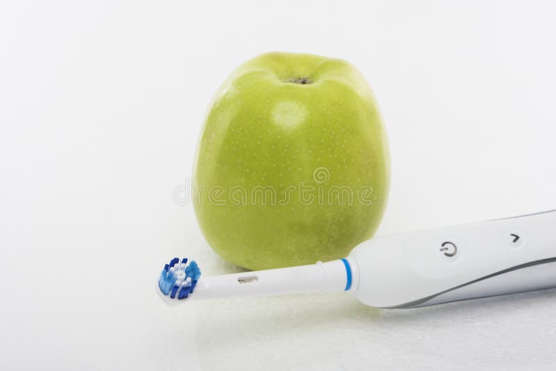 Concetto dentario di Hygien: Mela verde insieme a Toothb elettrico fotografia stock Concetto dentario di Hygien: Mela verde insieme a Toothb elettrico fotografia stock