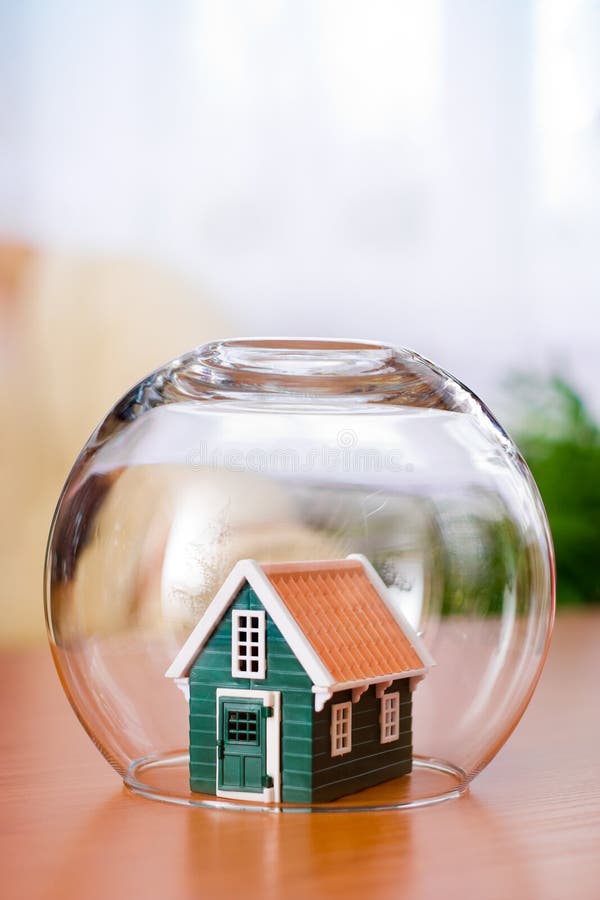 House insurance concept: covered with a glass ball to protect. House insurance concept: covered with a glass ball to protect