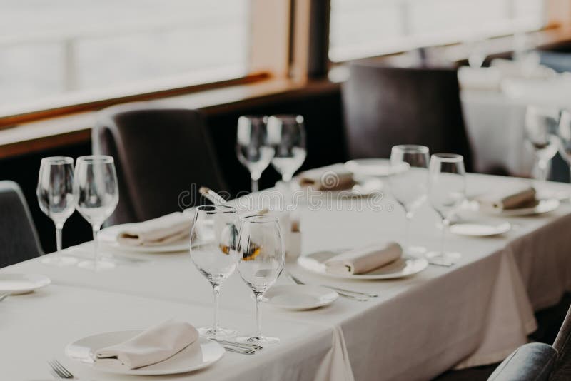Concetto di celebrazione e di approvvigionamento Tavola di cena servita festiva con i vetri e la coltelleria sul tablewear bianco immagine stock libera da diritti Concetto di celebrazione e di approvvigionamento Tavola di cena servita festiva con i vetri e la coltelleria sul tablewear bianco immagine stock libera da diritti