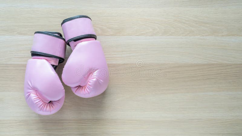 Breast cancer awareness concept with pink boxing gloves for girl and woman sports fight and recreational exercise on white wood background with copy space. Breast cancer awareness concept with pink boxing gloves for girl and woman sports fight and recreational exercise on white wood background with copy space.