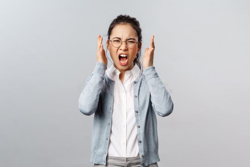 Emotions, people and lifestyle concept. Aggressive young annoyed asian woman have emotional working burnout, screaming with hate and rage, staring furious grimacing, shaking hands in anger. Emotions, people and lifestyle concept. Aggressive young annoyed asian woman have emotional working burnout, screaming with hate and rage, staring furious grimacing, shaking hands in anger.