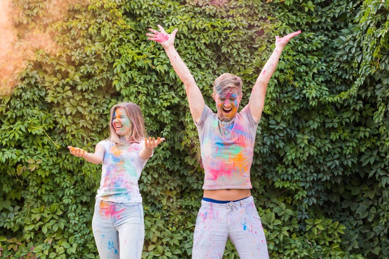 Concetto di festa, di holi e della gente - divertiresi felice delle coppie coperto in pittura fotografia stock Concetto di festa, di holi e della gente - divertiresi felice delle coppie coperto in pittura fotografia stock