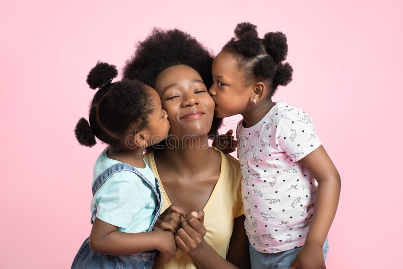 Concetto di maternità e di famiglia. adorabili due ragazzine africane in costume estivo che si divertono e baciano le loro fotografie stock