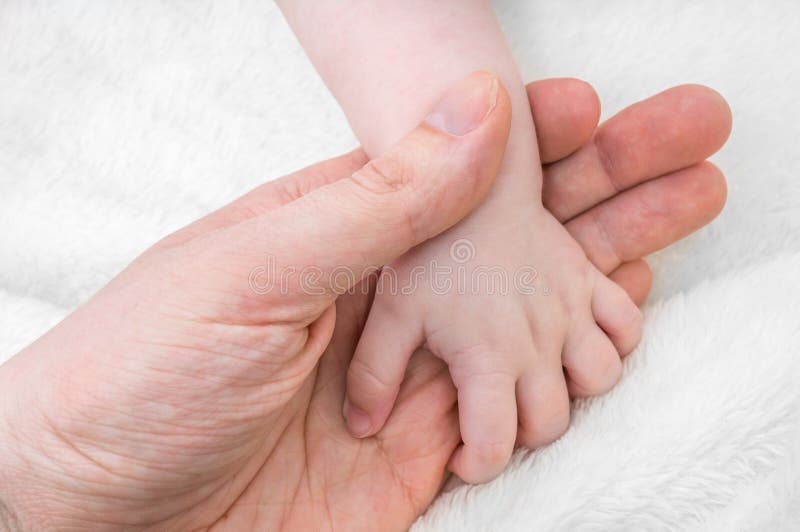 Concetto di puericultura Il padre tiene la mano del suo bambino fotografia stock Concetto di puericultura Il padre tiene la mano del suo bambino fotografia stock