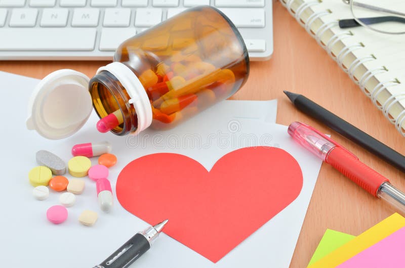 Concetto di sanità - cuore rosso con il supplemento sullo scrittorio del computer immagini stock libere da diritti Concetto di sanità - cuore rosso con il supplemento sullo scrittorio del computer immagini stock libere da diritti