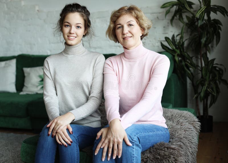 Concetto di stile di vita, della famiglia e della gente: Giovane donna felice e sua madre a casa immagine stock Concetto di stile di vita, della famiglia e della gente: Giovane donna felice e sua madre a casa immagine stock