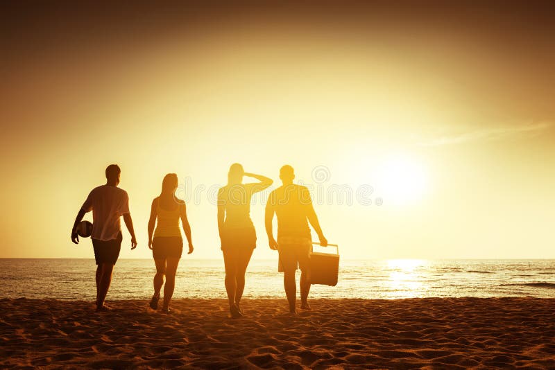 Concetto di tramonto della spiaggia degli amici con roba fotografie stock Concetto di tramonto della spiaggia degli amici con roba fotografie stock