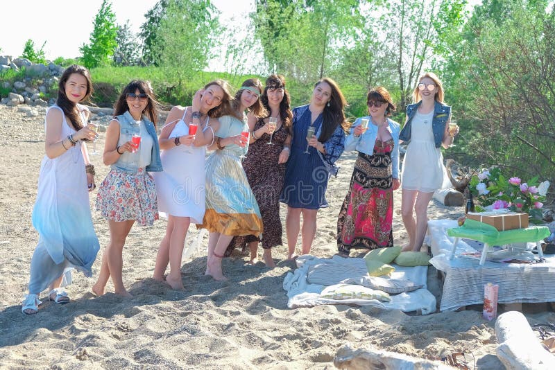 Concetto di vacanze estive - il gruppo di giovani donne sorridenti sta riposando sulla spiaggia fotografia stock Concetto di vacanze estive - il gruppo di giovani donne sorridenti sta riposando sulla spiaggia fotografia stock