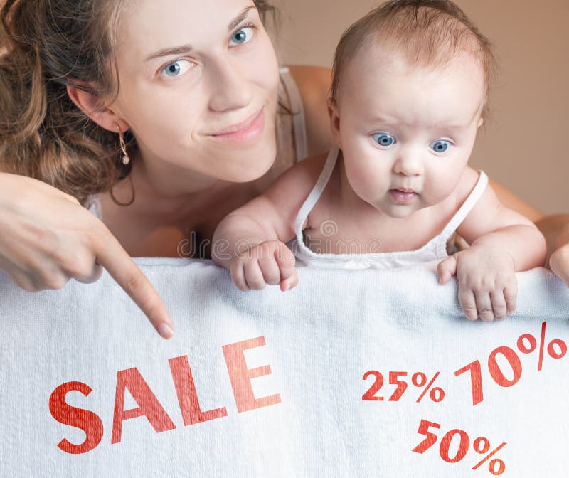 Concetto di vendita con la mamma ed il bambino che si trovano sulla coperta bianca fotografie stock Concetto di vendita con la mamma ed il bambino che si trovano sulla coperta bianca fotografie stock