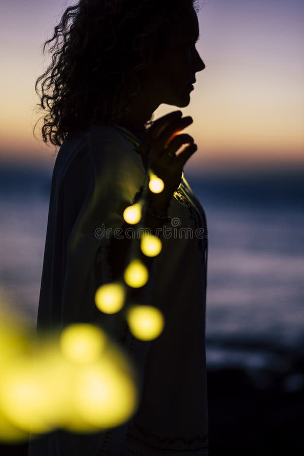 Concetto di vita romantica con donna in piedi e bulbo giallo romantico chiaro - sfondo naturale sfocato con tramonto colorato fotografia stock libera da diritti Concetto di vita romantica con donna in piedi e bulbo giallo romantico chiaro - sfondo naturale sfocato con tramonto colorato fotografia stock libera da diritti