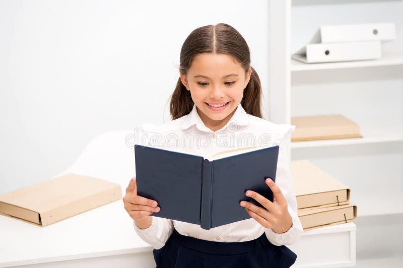 Concetto emozionante della letteratura Il bambino della ragazza ha letto l'interno bianco del supporto di libro Scolara che studi fotografie stock libere da diritti Concetto emozionante della letteratura Il bambino della ragazza ha letto l'interno bianco del supporto di libro Scolara che studi fotografie stock libere da diritti