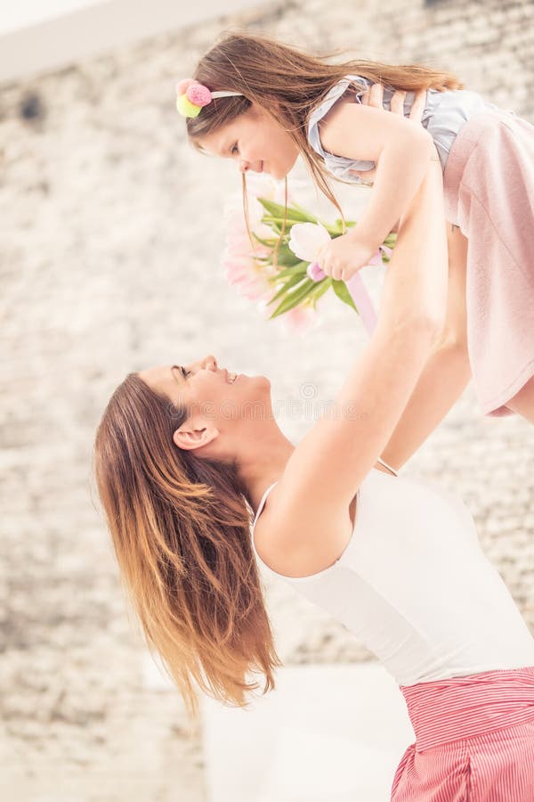 Concetto felice di giorno del ` s della madre La mamma prende il suo bambino dalla gioia sopra la sua testa fotografie stock Concetto felice di giorno del ` s della madre La mamma prende il suo bambino dalla gioia sopra la sua testa fotografie stock