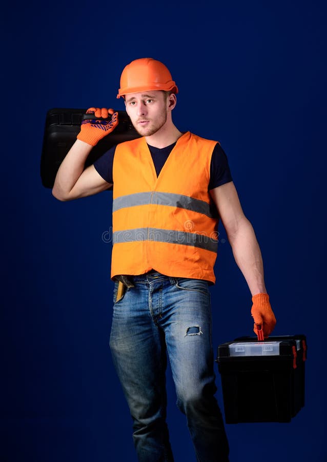 Concetto fornito del riparatore Il lavoratore, tuttofare, riparatore, costruttore sul fronte calmo porta la valigia con gli strum fotografia stock Concetto fornito del riparatore Il lavoratore, tuttofare, riparatore, costruttore sul fronte calmo porta la valigia con gli strum fotografia stock