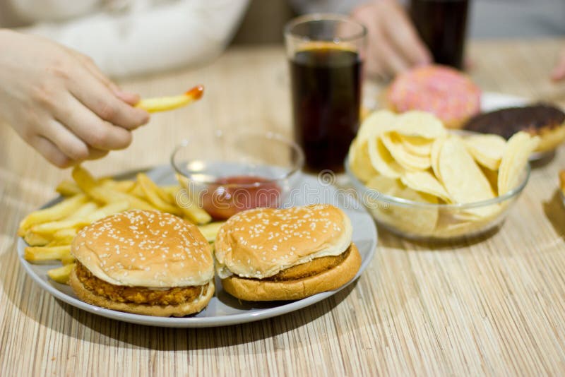 Concetto non sano Una coppia di amici stanno sedendo alla tavola immagini stock Concetto non sano Una coppia di amici stanno sedendo alla tavola immagini stock