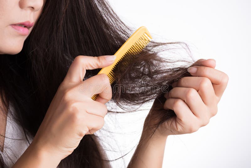 Concetto sano La donna mostra la sua spazzola con i capelli lunghi nocivi di perdita e l'esame dei suoi capelli