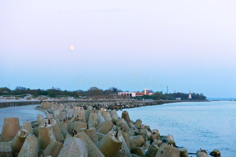 Pier sea and coastal fortifications, concrete breakwaters protecting the sea shore, full moon and sea pier, baltic sea royalty free stock photo Pier sea and coastal fortifications, concrete breakwaters protecting the sea shore, full moon and sea pier, baltic sea royalty free stock photo