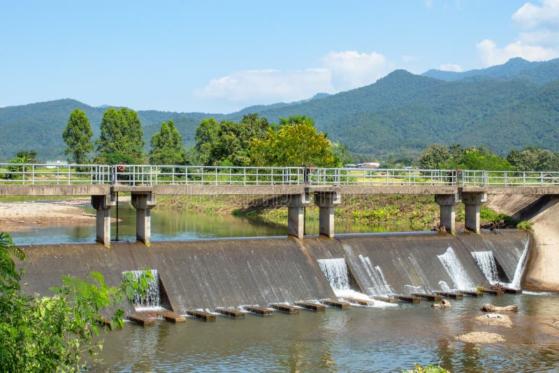 Concrete bridge over the weir in the river. Which flows from the stock image