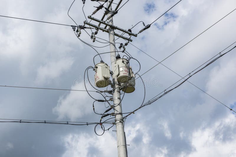Concrete Gray Round Electric Pole with Transverse Brown Metal Diamondshaped Frames Construction