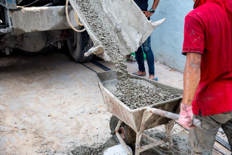 Concrete mixed cement pouring from mortar grinder truck to trolley holding by worker stock image Concrete mixed cement pouring from mortar grinder truck to trolley holding by worker stock image