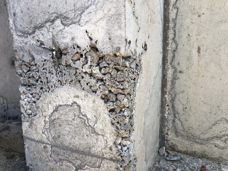 Concrete Surface with Caverns and Exposed Gravel Stones and