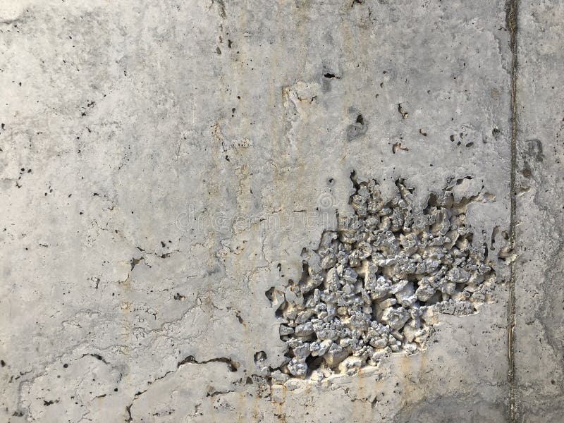 Concrete Surface with Caverns and Exposed Gravel Stones and