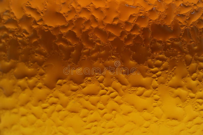 Condensation on the amber and gold color gradation glass bottle for texture background