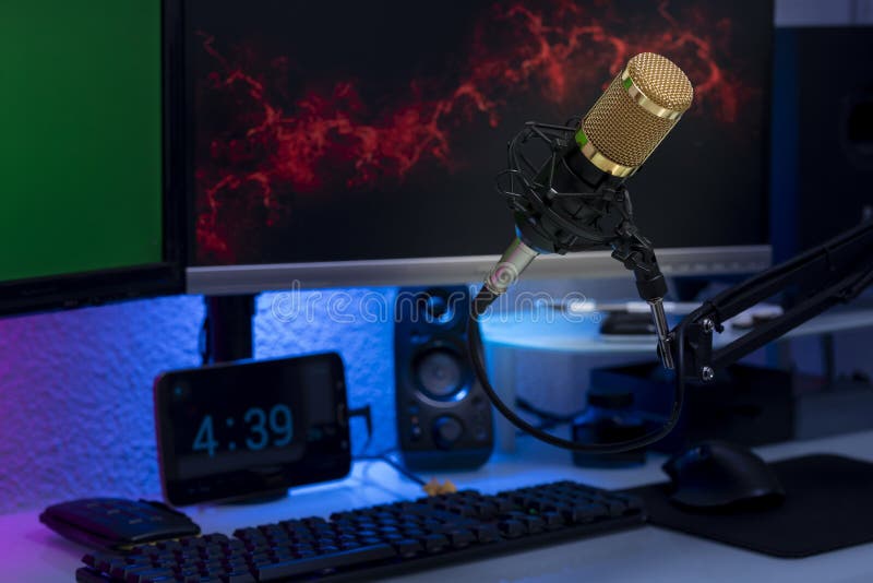 Condenser Microphone in Gamer Setup with Monitors, Keyboard, Mouse and Colored Lights Stock