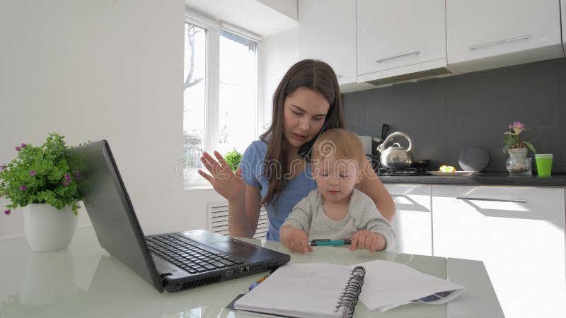 Condition parentale dure, maman multitâche avec pleurer peu de garçon d'enfant tout en travaillant sur l'ordinateur portable et p