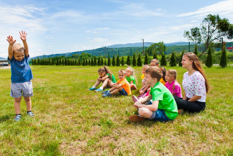 Condizione adorabile del ragazzo davanti al gruppo di bambini fotografie stock libere da diritti Condizione adorabile del ragazzo davanti al gruppo di bambini fotografie stock libere da diritti
