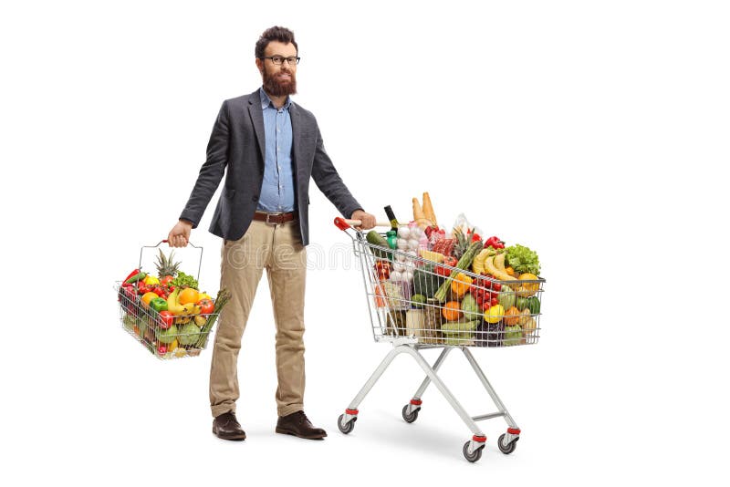 Condizione del giovane con un carrello e un cestino della spesa con la frutta e le verdure fotografia stock libera da diritti Condizione del giovane con un carrello e un cestino della spesa con la frutta e le verdure fotografia stock libera da diritti