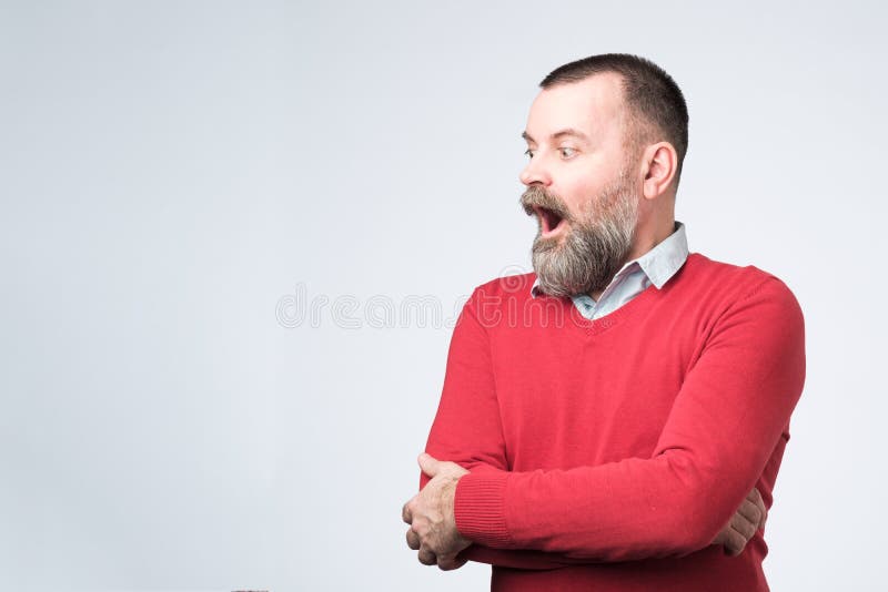 Condizione dell'uomo con la bocca aperta che guarda da parte fotografia stock libera da diritti Condizione dell'uomo con la bocca aperta che guarda da parte fotografia stock libera da diritti