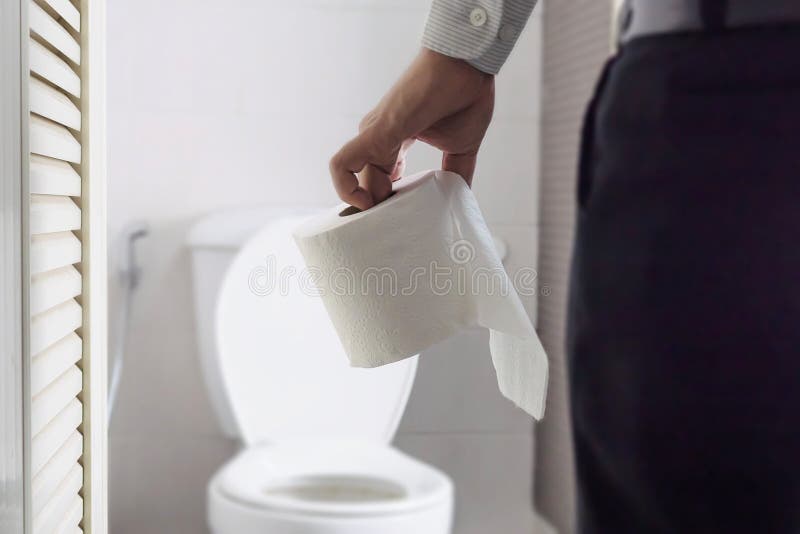 Condizione della carta velina della tenuta dell'uomo accanto alla ciotola di toilette