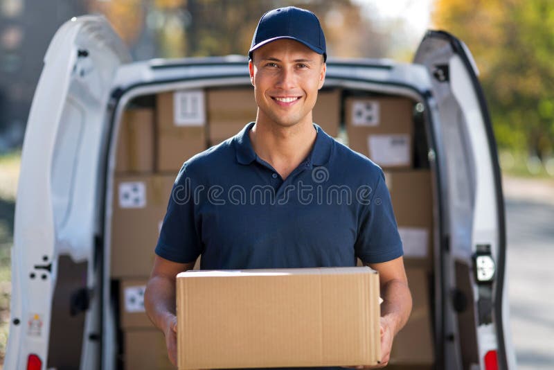 Condizione sorridente del fattorino davanti al suo van holding un pacchetto