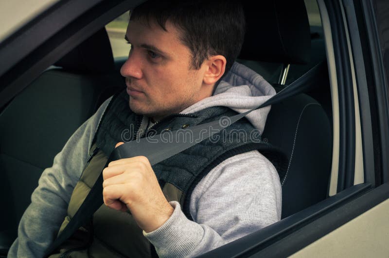 Conducción De Un Hombre Sujeta El Cinturón De Seguridad Imagen de archivo de mano, correa: 88783001