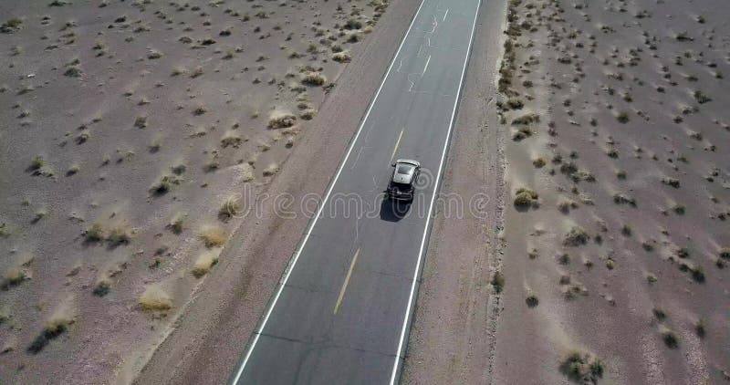 Conduire la voiture foncée de SUV sur la route dans Death Valley aux Etats-Unis