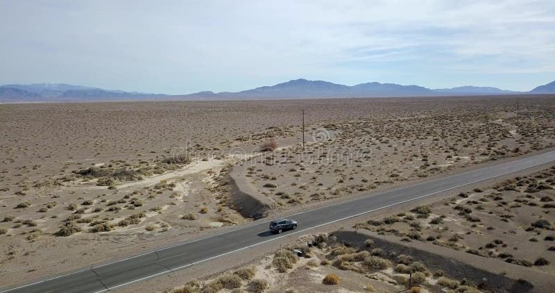 Conduire la voiture gris-foncé de SUV sur la route dans Death Valley aux Etats-Unis