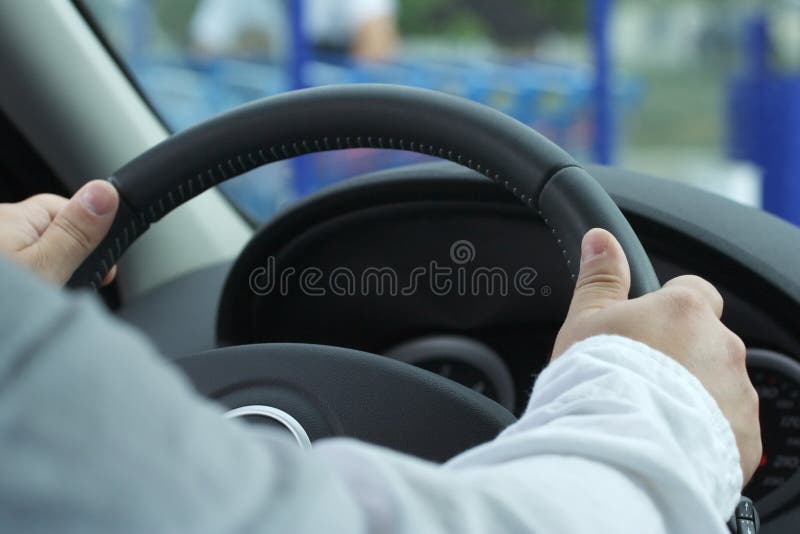 This man drives his car with the two hands. This man drives his car with the two hands