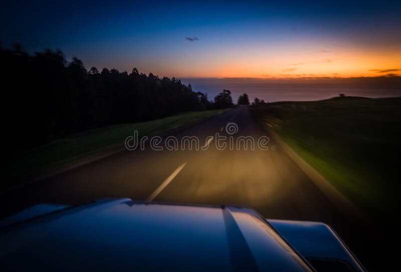 View from the front window of a jeep driving on a countryside road at sunset. View from the front window of a jeep driving on a countryside road at sunset